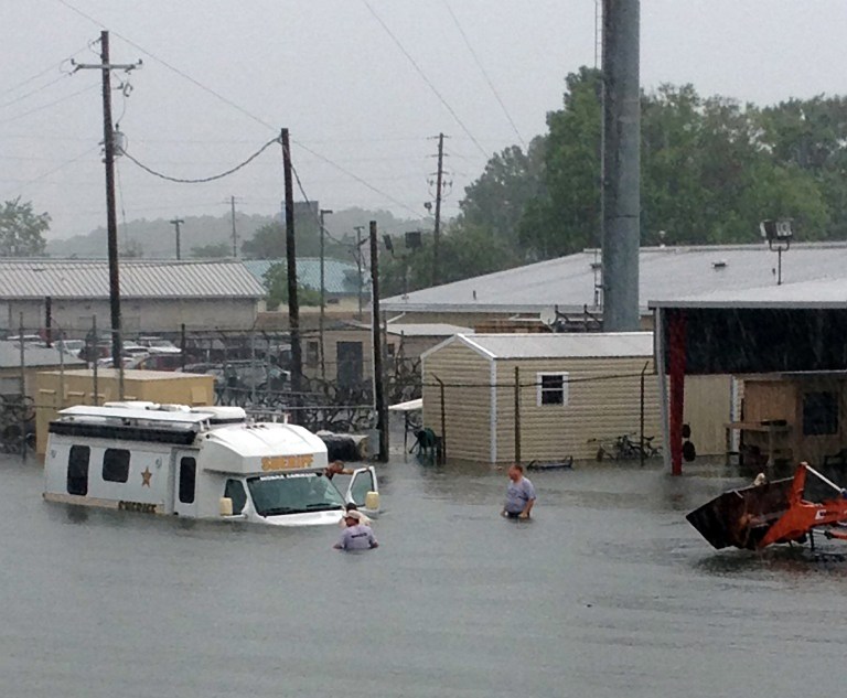   In this Saturday, June 9, 2012 photo provided by the Escambia County SheriffÃs Department, people wade through high floodwaters near a sheriff's department vehicle, in Escambia County. Floodwaters from torrential rains damaged homes and closed roads throughout the Florida Panhandle, cutting power to the county jail and sending residents to emergency shelters as the area braced for additional rains Sunday. (AP Photo/Escambia County Sheriff's Department)  
