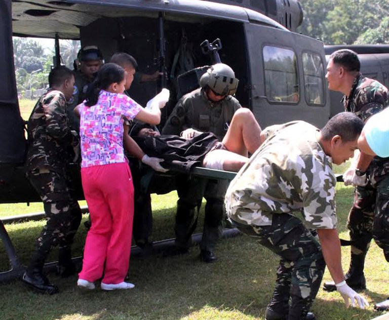 Philippine troops rush a victim injured in a bombing to a military hospital after being airlifted from the site of an improvised explosive devise explosion Saturday, Feb. 1, 2014 at Datu Saudi Ampatuan township, Maguindanao province in southern Philippines. A homemade bomb that was likely set off by Muslim rebels in the southern Philippines on Saturday wounded 12 people, including six soldiers and two television journalists, the military said. The blast happened near an area where government troops have been battling Muslim insurgents who broke away from a larger rebel group after it signed a peace deal with the government. (AP Photo)