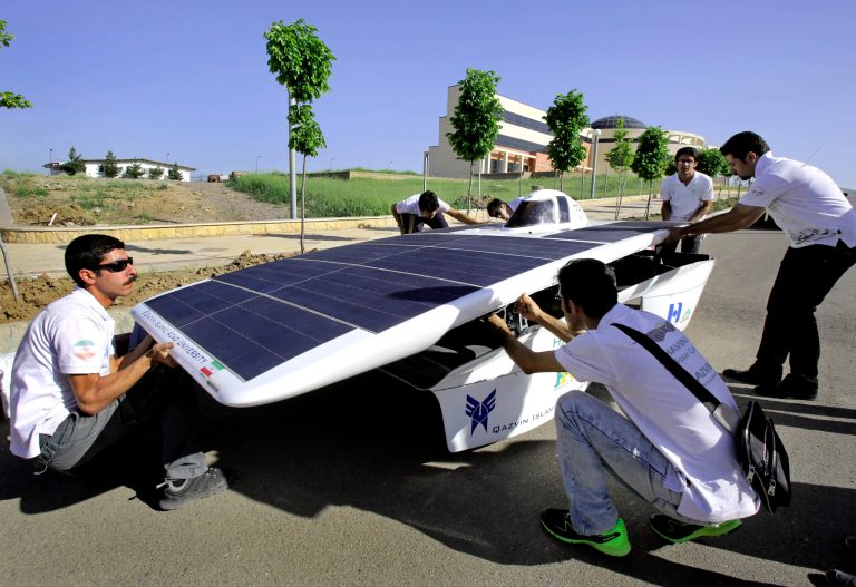 In this April 30, 2014 photo, Qazvin Azad University students assemble the Havin-2, or Brilliant Sun, for a test drive in Qazvin, Iran. A group of Iranian students and their teachers geared up for a summer road trip through the American heartland, fueled only by the sun and their hopes to shine in what will be a first for the Islamic Republic. The flat, rectangular Havin-2, drove for tests alongside slightly larger gas-powered motor vehicles outside the capital, Tehran, ahead of the eight-day, 1,700-mile (2,700-kilometer) race that will take it from Austin, Texas, to Minneapolis. (AP Photo/Vahid Salemi)