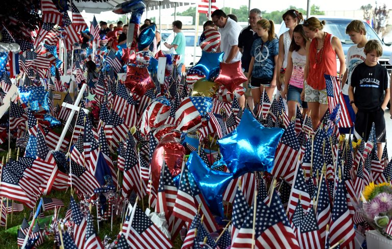 People pay their respects by a makeshift memorial outside the Armed Forces Career Center Tuesday, July 21, 2015, in Chattanooga, Tenn. (AP Photo)Â 