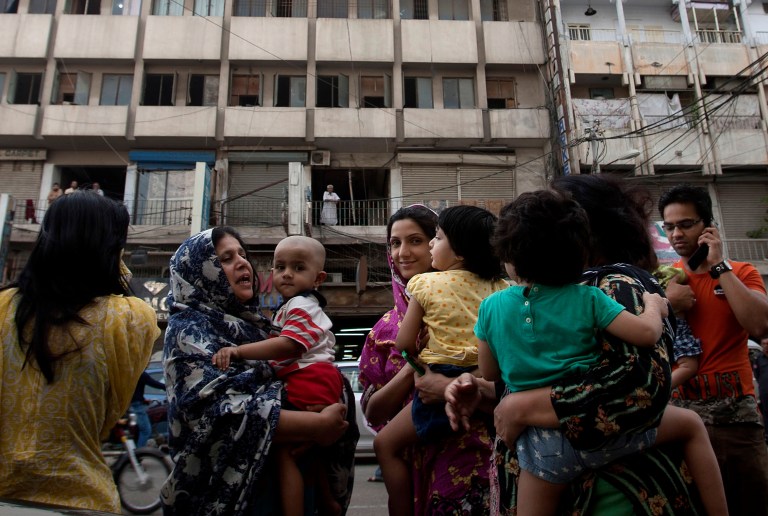 People evacuate buildings and gather on road as tremor of an earthquake was felt in Karachi, Pakistan, Tuesday, April 16, 2013. A major earthquake described as the strongest to hit Iran in more than half a century flatted homes and offices Tuesday near Iran's border with Pakistan, killing at least tens of people in the sparsely populated region and swaying buildings as far away as New Delhi and the skyscrapers in Dubai and Bahrain. (AP Photo/Shakil Adil)