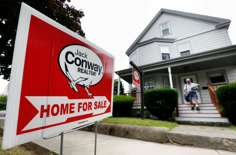 In this July 10, 2014 photo, a mailman delivers mail to a house for sale in Quincy, Mass. Standard & Poor's/Case-Shiller reports on U.S. home prices in May on Tuesday, July 29, 2014. (AP Photo/Michael Dwyer)