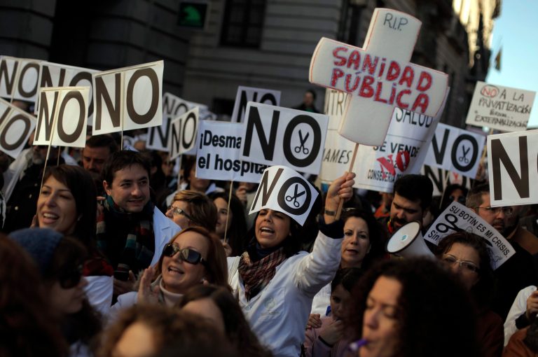   Protestors hold banners reading, 