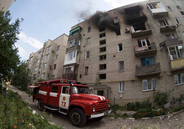 A fire truck arrives at a burning building after shelling in Maryinka village, outside the city of Donetsk, eastern Ukraine, Saturday, July 12, 2014. (AP Photo/Dmitry Lovetsky)