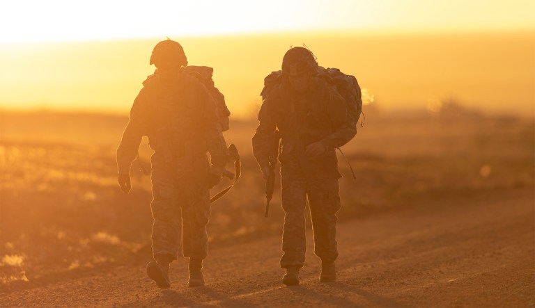 Army Spcs. Eduardo Siordia and Keith Zimmerman approach the midpoint of a 12-mile ruck march during the Best Warrior competition at Fort Carson, Colo., April 26, 2019. The multiday event tests competitors' physical fitness, military knowledge, marksmanship and endurance.