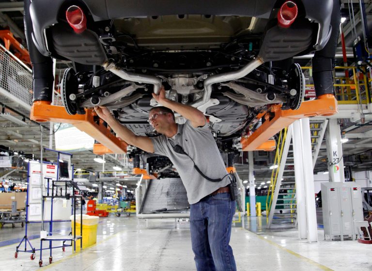 Jeff Caldwell, 29, a chassis assembly line supervisor, checks a vehicle on the assembly line at the Chrysler Jefferson North Assembly plant in Detroit on May 8. (AP Photo/Paul Sancya, File)
