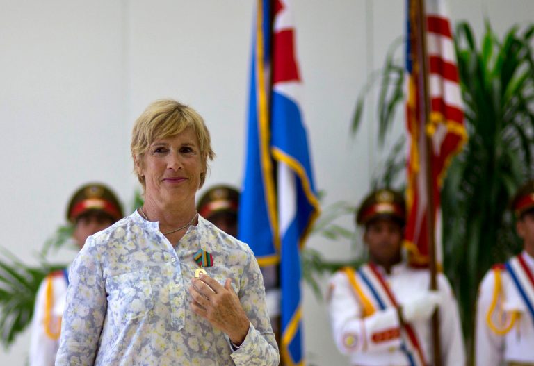 U.S. endurance swimmer Diana Nyad wears her Order of Sporting Merit medal as she stands in front of the Cuban and U.S. flags during a ceremony in Havana, Cuba, Saturday, Aug. 30, 2014. Cuba honored Nyad for being the first swimmer to make the crossing between Cuba and Florida without flippers or a shark cage for protection. Nyad made four previous attempts; first in 1978, and three times in 2011 and 2012. (AP Photo/Ramon Espinosa)