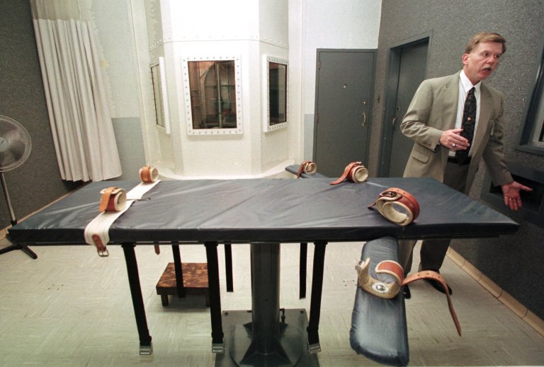 Leonard A. Sipes, Jr. director of public information for the Department of Public Safety and Correctional Services, describes the procedure for carrying out an execution in the Death House of the Maryland Penitentiary Hospital in Baltimore, Saturday, Nov. 14, 1998. In foreground is the gurney on which inmate Tyrone Delano Gilliam is scheduled to be strapped for execution by lethal injection sometime during the week of Nov. 16, 1998. Windows at rear are for the gas chamber. (AP Photo/Roberto Borea)