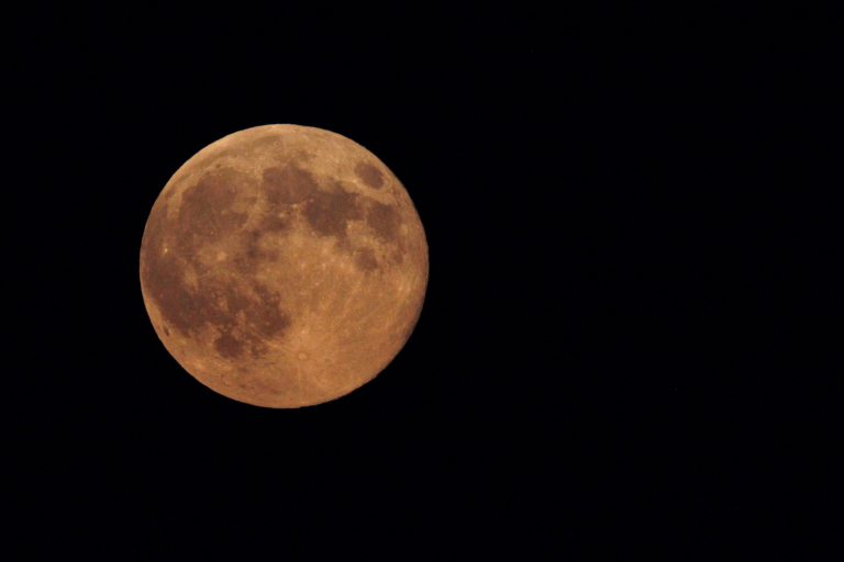 The supermoon appears yellow as the sky darkens over Edgartown, Mass., Sunday, Aug. 10, 2014, on the island of Martha's Vineyard. President Barack Obama and his family are vacationing on the island. (AP Photo/Jacquelyn Martin)