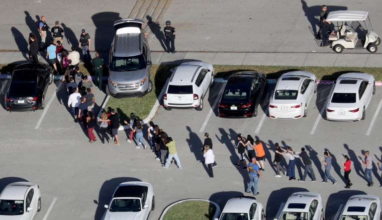 Students are evacuated by police from Marjory Stoneman Douglas High School in Parkland, Fla., after a shooter opened fire on the campus. (Mike Stocker/South Florida Sun-Sentinel via AP)