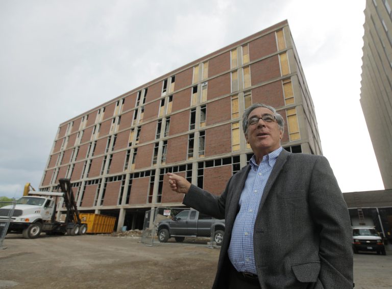 In this June 24, 2010 photo, developer Larry Glazer gestures toward a building to be demolished on Alexander Street in Rochester, N.Y. Glazer and wife, Jane, were aboard their small plane, which took off from the Greater Rochester International Airport, as it flew 1,700 miles down the East Coast on Friday, Sept. 5, 2014, before finally crashing off the coast of Jamaica. (AP Photo/Democrat & Chronicle, Carlos Ortiz)  MAGS OUT; NO SALES