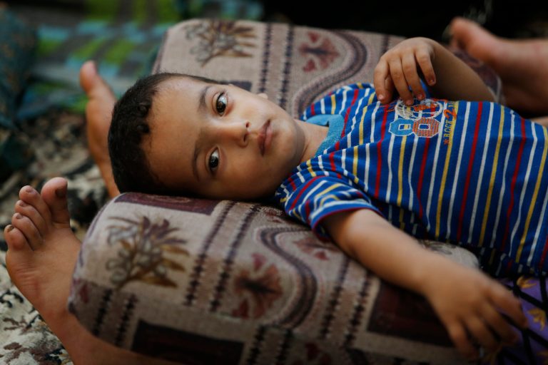Two and a half-year-old Muhammad Al Masri rests on his mother's legs in a classroom at a United Nations school where hundreds of families have sought refuge after fleeing their homes following heavy Israeli forces' strikes, in Jebaliya refugee camp, Gaza Strip, Friday, July 25, 2014. Over 140,000 Palestinians are seeking shelter in 83 UNRWA schools, according to UNRWA spokesman Chris Gunness. The number of Palestinians seeking shelter since the ground operation began has increased seven-fold. (AP Photo/Lefteris Pitarakis)