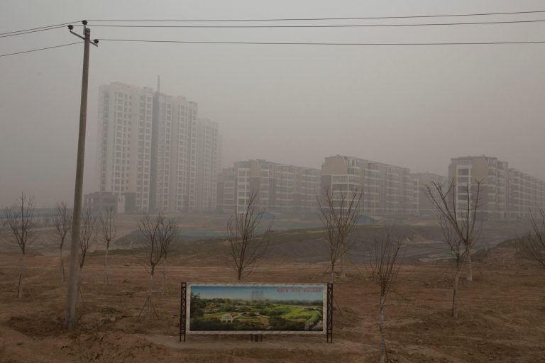 In this photo taken Wednesday, Feb. 26, 2014, an artistic rendering functioning as an advertisement of a residential real estate project is displayed on a severely polluted day in Shijiazhuang, in northern China's Hebei province. Combatting pollution has shot up the agenda of the ruling Communist Party, which for years pushed for rapid economic development with little concern about the environmental impact. Under public pressure to reduce the air pollution that blankets Beijing and cities across China, the country's leaders are rebalancing their priorities. (AP Photo/Alexander F. Yuan)