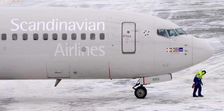   An airport worker walks away from an SAS Boeing 737 aircraft after it was pushed back from the terminal at Arlanda airport, north of Stockholm, Sweden, Wednesday, Dec. 12, 2012. Struggling Scandinavian airline SAS AB, which last month announced an aggressive cost-cutting plan in a final desperate attempt to avoid bankruptcy, reported a 3 billion kronor ($450 million) full-year loss on Wednesday. (AP Photo/Scanpix, Johan Nilsson) SWEDEN OUT  
