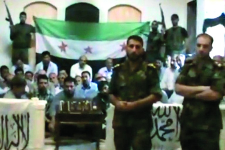 This image made from a video released by the Baraa Brigades and accessed Sunday, Aug. 5, 2012, purports to show Free Syrian Army soldiers guarding a group of Iranians abducted a day earlier and promising more attacks on Iranian targets in Damascus, Syria. Armed men in the video identify themselves as members of the rebel 