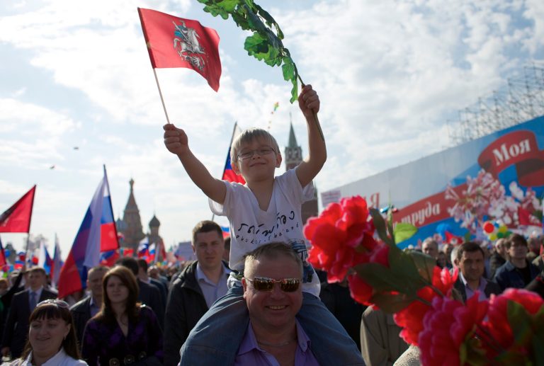 A boy and his father smile as they march with members of Russian Trade Unions during the May Day celebration in Red Square, Moscow, Russia, on Thursday, May 1, 2014. About 100,000 people have marched through Red Square to celebrate May Day, the first time the annual parade has been held on the vast cobblestoned square outside the Kremlin since the fall of the Soviet Union in 1991. (AP Photo/Ivan Sekretarev)