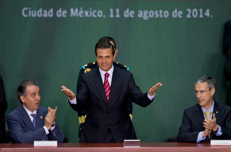 Mexican President Enrique Pena Nieto, center, is applauded by Senate leader Raul Cervantes Andrade, left, and House Speaker Jose Gonzalez Morfin at a ceremony to mark the signing of a historic energy reform bill, at the National Palace in Mexico City, Monday, Aug. 11, 2014. The law will open the state-run oil, gas and electricity industries to foreign and private companies. Mexico is hoping for tens of billions of dollars in outside investment in deep-water oil drilling and shale gas production. (AP Photo/Rebecca Blackwell)