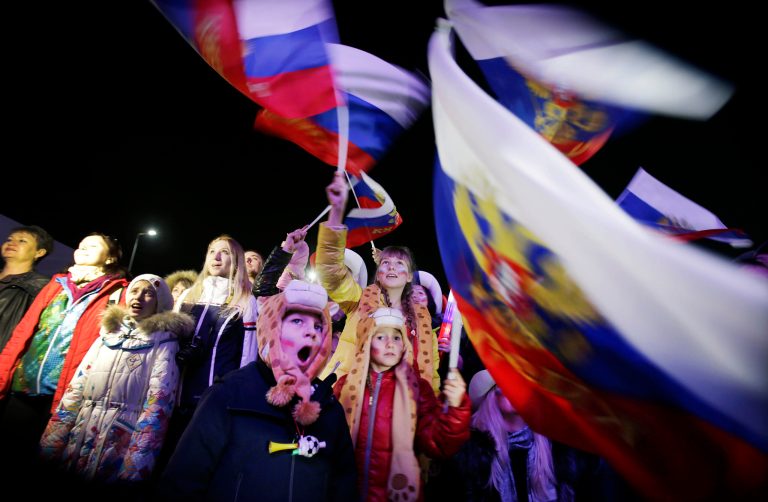 A Russian child yawns while others wave the national flag as the Russian national anthem is played during the live telecast of the 2014 Winter Olympics opening ceremony on Friday in Sochi, Russia. (AP Photo/Wong Maye-E)