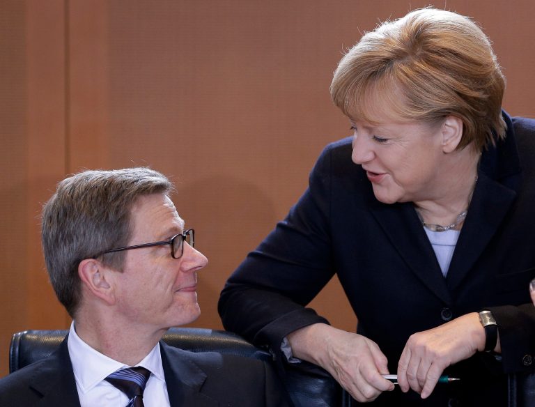   German Foreign Minister Guido Westerwelle, left, and German Chancellor Angela Merkel talk as they arrive for the weekly cabinet meeting at the chancellery in Berlin, Germany, Thursday, Dec. 6, 2012. (AP Photo/Michael Sohn)  
