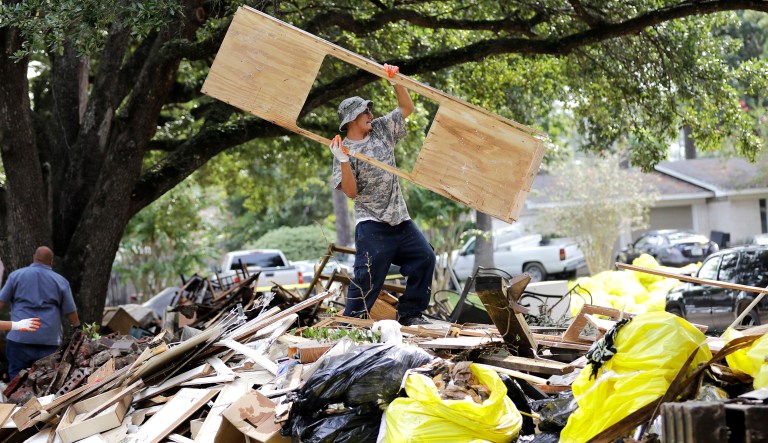 Rene Ramirez helps move debris from a home damaged by floodwaters in the aftermath of Hurricane Harvey on Wednesday, Sept. 6, 2017, in Spring, Texas. (AP Photo/David J. Phillip)
