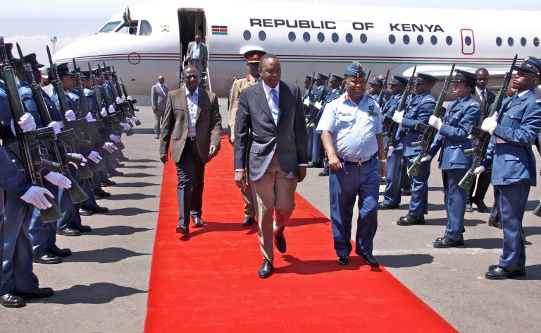 In this photo released by the Kenya Presidency, Kenyan President Uhuru Kenyatta, center, and Deputy President William Ruto, center-left, are welcomed back by Chief of the Defence Forces Staff Gen. Julius Karangi, center-right, after attending the African Union (AU) summit in Addis Ababa, at the airport in Nairobi, Kenya Saturday, Feb. 1, 2014. The African Union urged its members to 