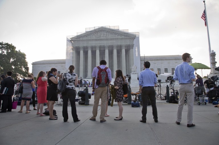 J. Scott Applewhite/AP
People wate outside the Supreme Court in Washington as key decisions are announced.