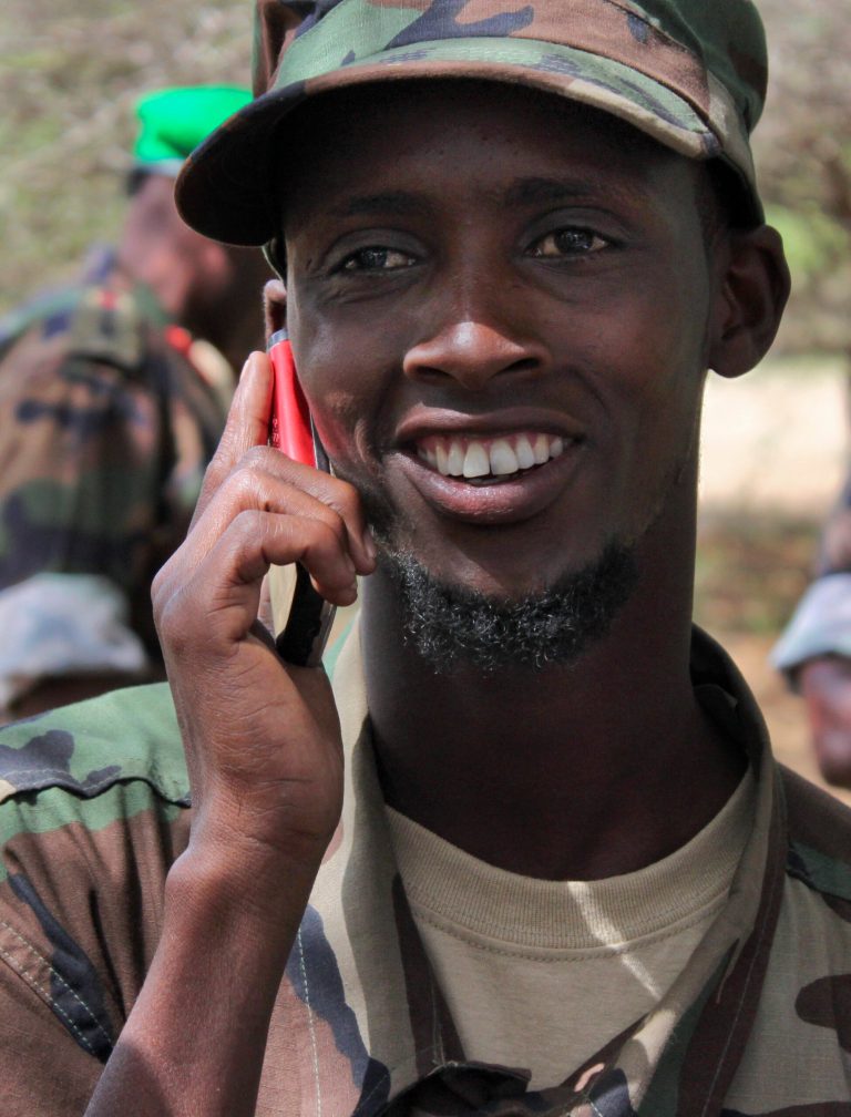   In this photo taken Thursday, June 7, 2012, Abshir Ali Mohamed, a defector from the Somali militant group al-Shabab who is now fighting with Somali government forces alongside the African Union (AU) peacekeeping force, receives a call from his former al-Shabab commander Sheik Mustaf, while speaking to the media at the AU base in Elasha Biyaha on the outskirts of Mogadishu, Somalia Thursday, June 7, 2012. Somali military and government leaders say Mohamed's defection is an example of a trend growing in their favor, with the East African country's most notorious militant group losing manpower and ground. (AP Photo/Jason Straziuso)  