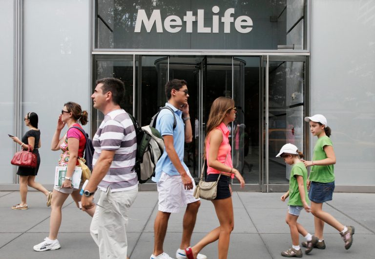 People pass MetLife offices, Monday, Aug. 6, 2012 in New York. Regulators declared the insurance company MetLife officially too big to fail Thursday, setting it up to be regulated like a bank. (AP Photo/Mark Lennihan)