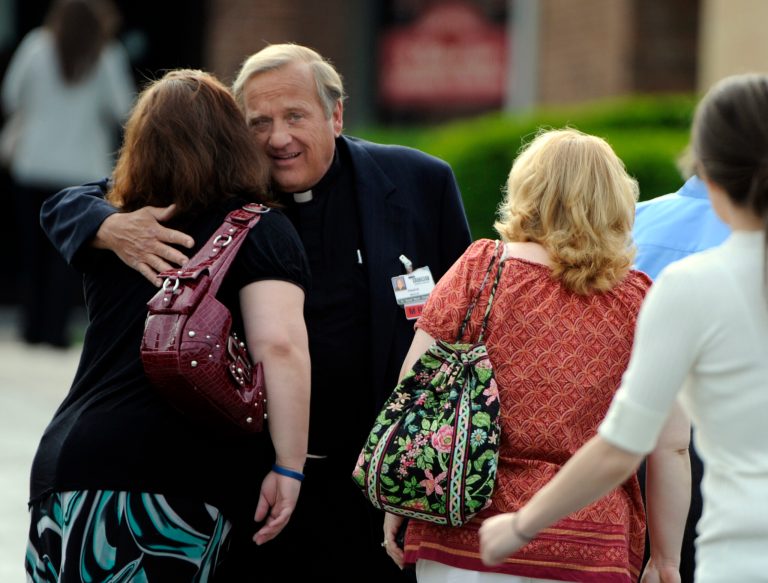   Father Francis X. Mazur of Erie County Medical Center, greets mourners before the funeral for Jacqueline Wisniewski at St. Martin of Tours Church in Buffalo, N.Y. Saturday, June 16, 2012. Wisniewski, 33, was killed Wednesday at ECMC, where she worked. Police said she was shot by ex-boyfriend Timothy Jorden, a doctor at the hospital. (AP Photo/Gary Wiepert)  