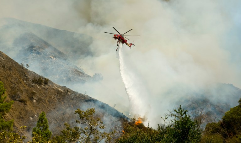 An Orange County Fire Authority helicopter drops a load of water on a brush fire in Silverado Canyon in Orange County, Calif. on Friday, Sept. 12, 2014. (AP Photo/Orange County Register, Sam Gangwer)
