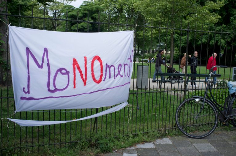 Visitors of the Wertheim Park point to a banner opposing plans for a second Holocaust monument in the park in Amsterdam, Netherlands, Wednesday, June 18, 2014. Plans for a second Holocaust monument in the park in Amsterdam designed by architect Daniel Libeskind have been put on hold after angry neighbors told the city it is too large for the park where it was to have been placed. Edwin Oppedijk, a spokesman for the city's central district, said Wednesday that after hearing the complaints, the city will reconsider whether to place the monument in the Wertheim Park after all or possibly an alternate location. (AP Photo/Peter Dejong)