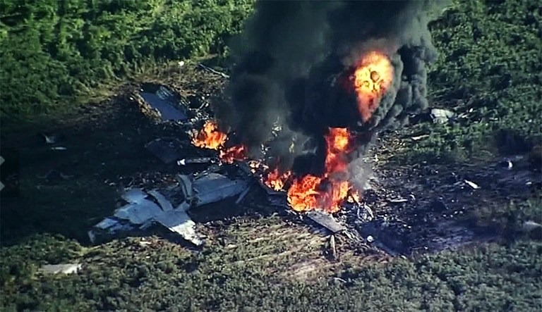 Smoke and flames rise from a Marine plane that crashed in a farm field, in Itta Bena, Miss., killing several. (WLBT-TV via AP)