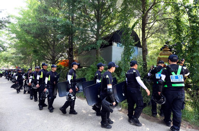 Police officers raid into a religious facility of the Evangelical Baptist Church in Anseong, South Korea, Thursday, June 12, 2014. Several thousand police officers,  6,000 on Wednesday and another 3,000 on Thursday, were mobilized to raid the sprawling South Korean church compound near Seoul to hunt for Yoo Byung-eun, a fugitive billionaire businessman and member of the church wanted in relation to the deadly ferry sinking in April. (AP Photo/Yonhap, Suh Myong-geun)  KOREA OUT