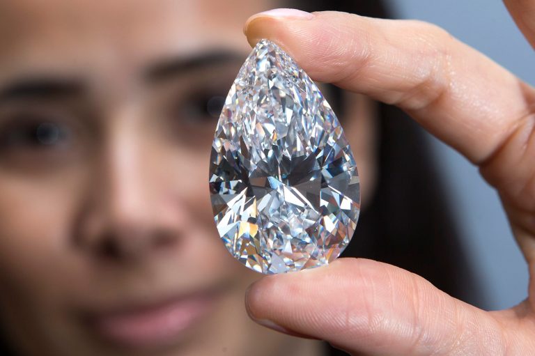 FILE -In this April 30, 2013 file picture a Christie's employee displays the largest colour flawless diamond, weighing 101.73 carats, during a preview at Christie's auction house in Geneva, Switzerland,. The largest pear-shaped colour flawless diamond is expected to reach US $ 30 million and it will be the hightlight at the Christie's auction on Wednesday May 15 , 2013 in Geneva. (AP Photo/keystone, Salvatore Di Nolfi,File)