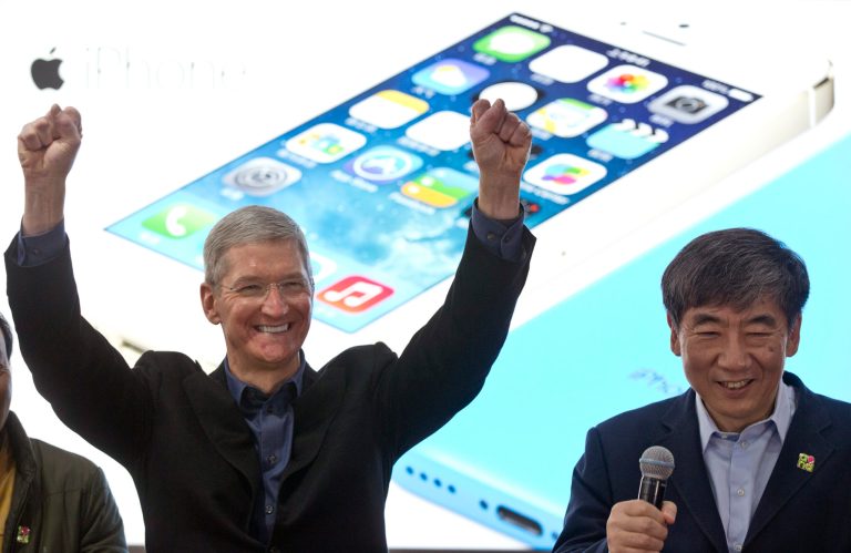 FILE - In this Jan. 17, 2014 file photo, Apple's CEO Tim Cook, left, gestures as China Mobile Chairman Xi Guohua smiles during a promotional event that marks the opening day of sales of China Mobile's 4G iPhone 5s and iPhone 5c in Beijing, China. Soaring sales of iPhones in China, Russia, India and Brazil during the April-June 2014 period helped Apple overcome softening demand for the device in the U.S. and Europe, where consumers seem to be more interested in waiting for the autumn release of a new iPhone that's expected to feature a larger screen. (AP Photo/Alexander F. Yuan, File)