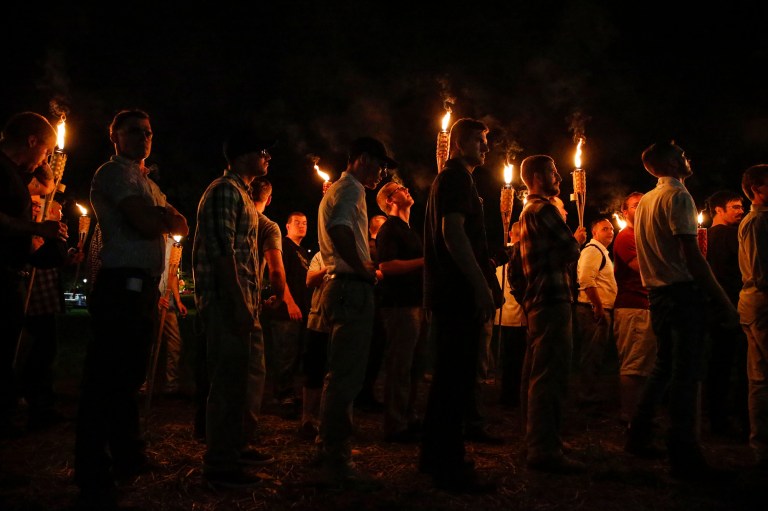 In this photo taken Friday, Aug. 11, 2017, multiple white nationalist groups march with torches through the UVA campus in Charlottesville, Va. Hundreds of people chanted, threw punches, hurled water bottles and unleashed chemical sprays on each other Saturday after violence erupted at a white nationalist rally in Virginia. (Mykal McEldowney/The Indianapolis Star via AP)