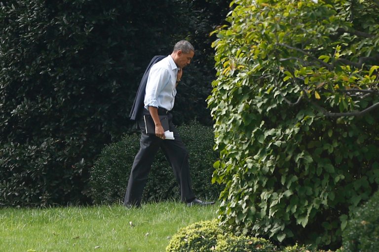 President Obama walks back to the Oval Office after a visit to Martha's Table, which assists the poor and where furloughed federal employees are volunteering, in Washington, Monday. Obama spoke about the government shutdown and the looming debt default during remarks to reporters during his visit. (AP Photo/Charles Dharapak)