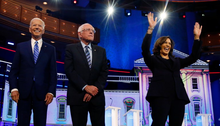 Democratic presidential candidates former vice president Joe Biden, left, Sen. Bernie Sanders, I-Vt., and Sen. Kamala Harris, D-Calif., right, stand on stage for a photo op before the start of the the Democratic primary debate hosted by NBC News at the Adrienne Arsht Center for the Performing Arts, Wednesday, June 27, 2019, in Miami.