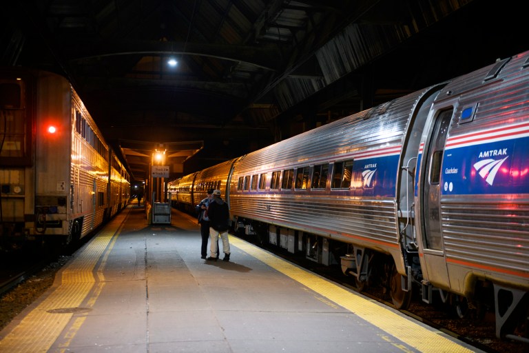 A train conductor assists a passenger on the terminal of Union Station in Pittsburgh on April 12.