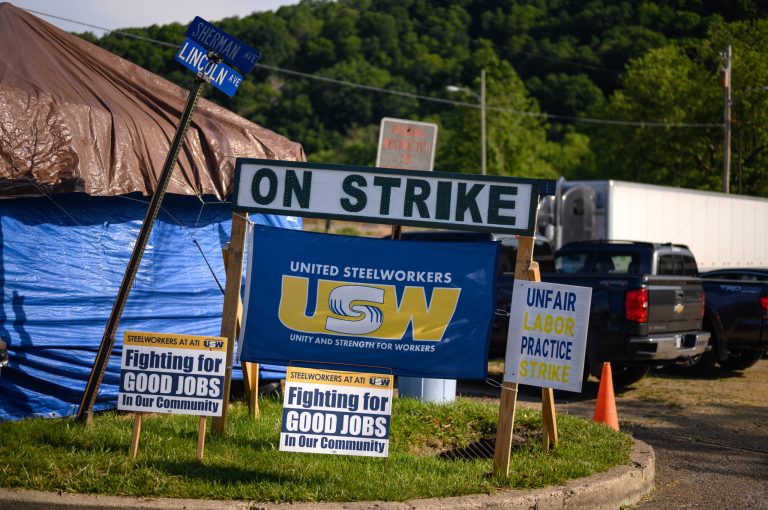 Signs sit along the road where members of the United Steelworkers Local 1138 picket in front of Allegheny Technologies Inc.âs Vandergrift mill where they are on strike on June 18 in Vandergrift, Pa. 
