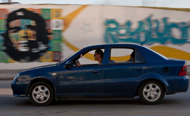 In this  July 7, 2014, photo, a Chinese made vehicle passes in front of a mural of revolutionary hero Ernesto 