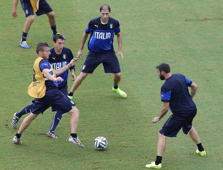 Italy's Ciro Immobile, left, and Matteo Darmian, second from left, vie for control of the ball, as Gabriel Paletta, top, and Andrea Barzagli watch during a training session, a the day before their group D World Cup soccer match, at the Arena das Dunas in Natal, Brazil, Monday, June 23, 2014. (AP Photo/Antonio Clanni)