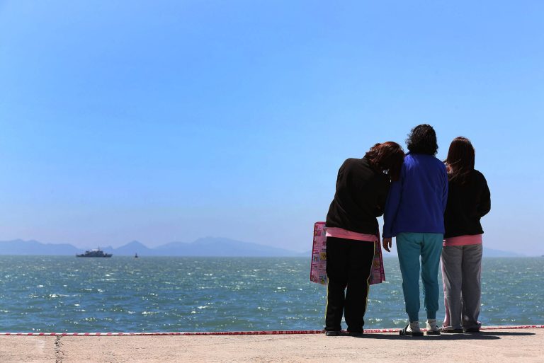 Relatives of a passenger aboard the sunken Sewol ferry look toward the sea at a port in Jindo, South Korea, Wednesday, April 30, 2014. South Korea's president apologized Tuesday for the government's inept initial response to a deadly ferry sinking as divers fought strong currents in their search for nearly 100 passengers still missing nearly two weeks after the accident.(AP Photo/Yonhap)  KOREA OUT