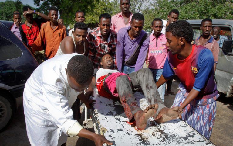 Somalis push a wounded civilian on a stretcher into a hospital following clashes between Somali troops and militiamen loyal to a Somali warlord in Mogadishu, Somalia Friday, Aug. 15, 2014. The sounds of warfare rattled Mogadishu residents from their beds early Friday as government troops launched a dawn attack on a house belonging to a former warlord as part of a disarmament campaign. (AP Photo/Farah Abdi Warsameh)