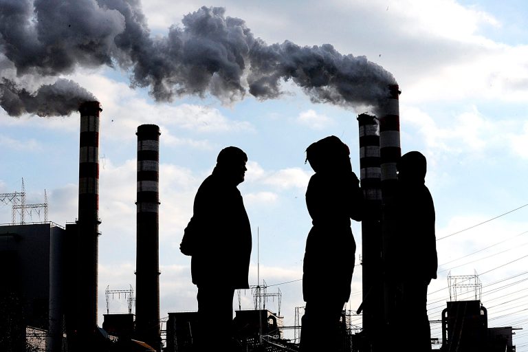 FILE - In this Dec. 2, 2008 file photo people stand in front of the Patnow coal-fuelled power plant near Konin, central Poland. Coal-reliant Poland is hosting UN climate talks but also a high-level coal industry event on the sidelines of the conference, in an occurrence that has infuriated climate activists. (AP Photo/Alik Keplicz)