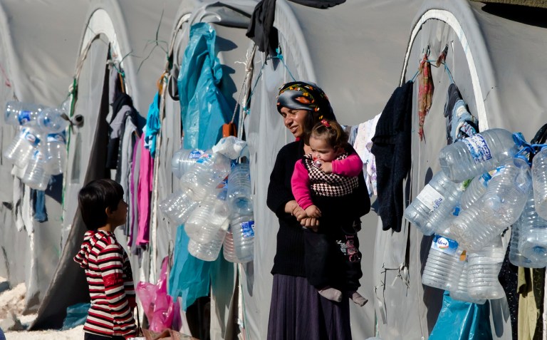 A Syrian Kurdish refugee woman from the Kobani area holds a baby at a camp in Suruc, on the Turkey-Syria border Wednesday, Nov. 19, 2014. Kobani, also known as Ayn Arab, and its surrounding areas, has been under assault by extremists of the Islamic State group since mid-September and is being defended by Kurdish fighters. (AP Photo/Vadim Ghirda)