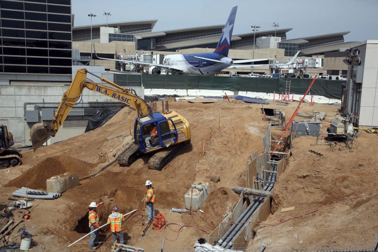 In this Monday, May 5,  2014 photo construction crews dig at Los Angeles International Airport, LAX.  An ongoing, multibillion-dollar renovation at the nation's third-busiest airport that has mostly been behind the scenes will soon start affecting passengers in ways large and small. LAX officials began warning the public about the coming inconveniences that will stretch over the next few years and affect traffic around the terminals and passenger movements inside them. (AP Photo/Nick Ut )