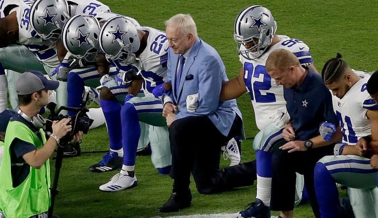 The Dallas Cowboys' owner Jerry Jones, center, took a knee before the national anthem prior to an NFL football game against the Arizona Cardinals on Monday. (AP Photo/Matt York)