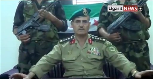 This Saturday July 21, 2012 image made from amateur video released by the Ugarit News and accessed Sunday, July 22, 2012, purports to show Syrian Brig. Gen. Abdul-Nasser Farzat, from the Aleppo Academy for Military Engineering, who claimed in another video to have defected to the Free Syrian Army, as he directs a message to Russia in Russian in Aleppo, Syria. (AP Photo)