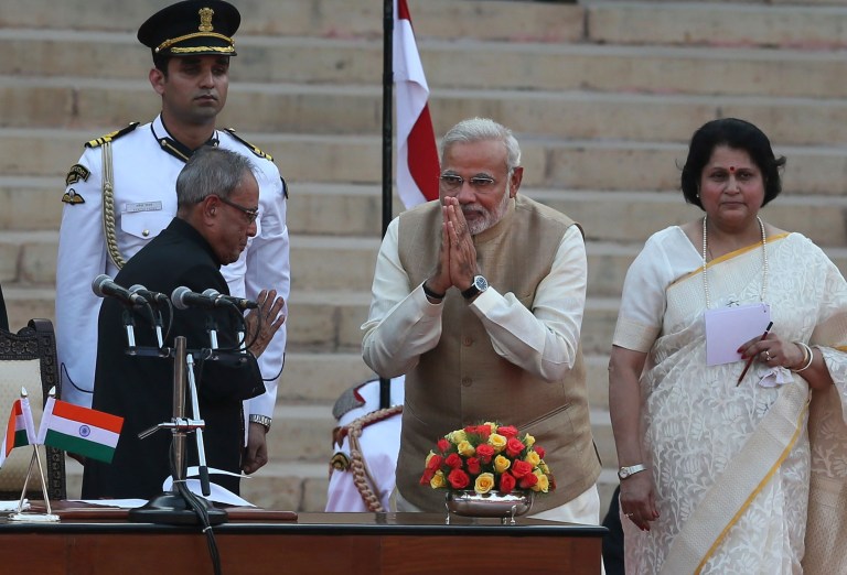 India's new prime minister Narendra Modi, center, greets President Pranab Mukherjee, left, after taking oath of office at the presidential palace in New Delhi, India, Monday, May 26, 2014. Modi's inauguration is the first to which India invited leaders from across South Asia.  (AP Photo /Manish Swarup)